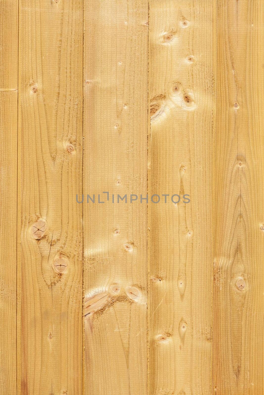 Light brown wooden wall on a construction fence with knotholes, Germany