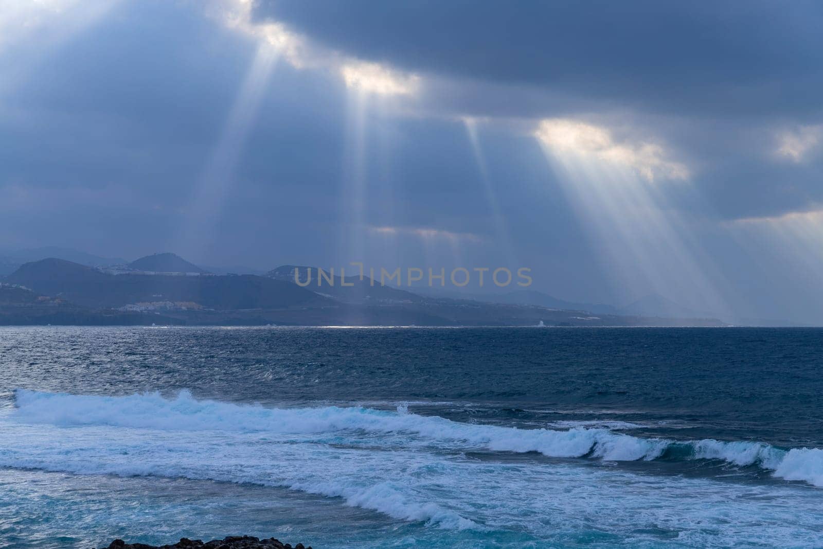 Beautiful sunrays on the Atlantic coast in Las Palmas de Gran Canaria, view from Las Canteras beach