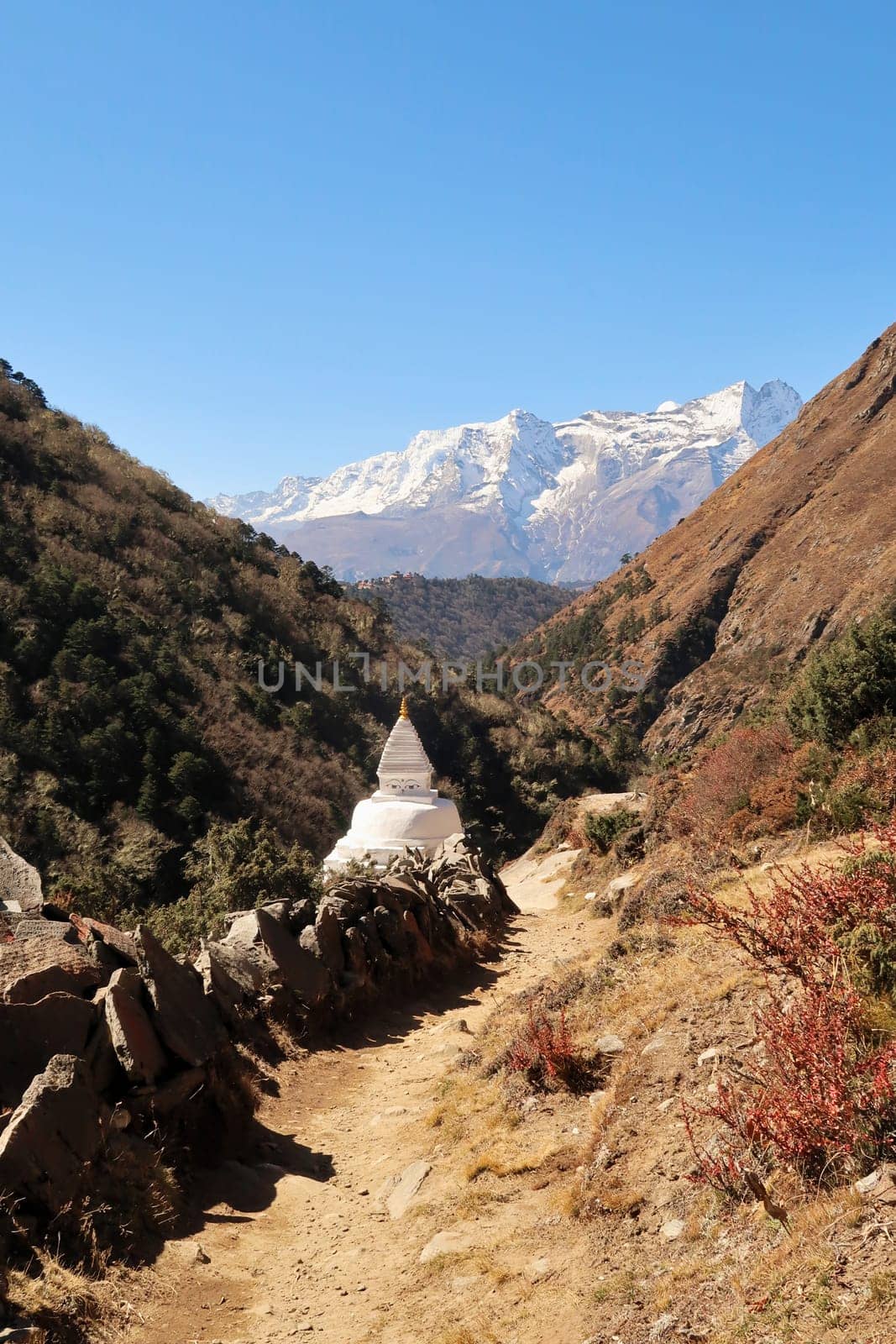 Stupa and many stacked Mani stones next to the trail, Tengboche, Tangboche village in front of Kongde Ri peak in the background, Mount Everest Base Camp Trek, EBC, Nepal 2022