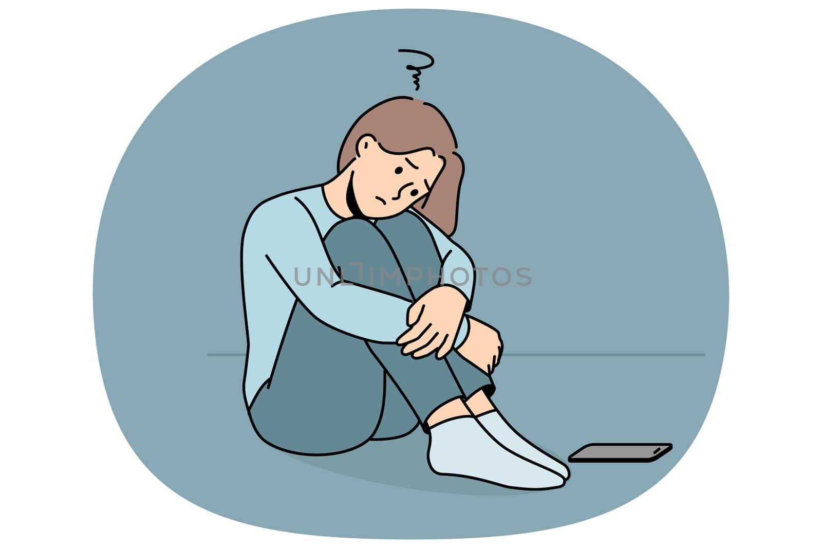 Sad woman is waiting for phone call, sitting on floor and suffering from loneliness or lack of friends. Sad girl sadly awaits arrival of sms message about replenishing bank account