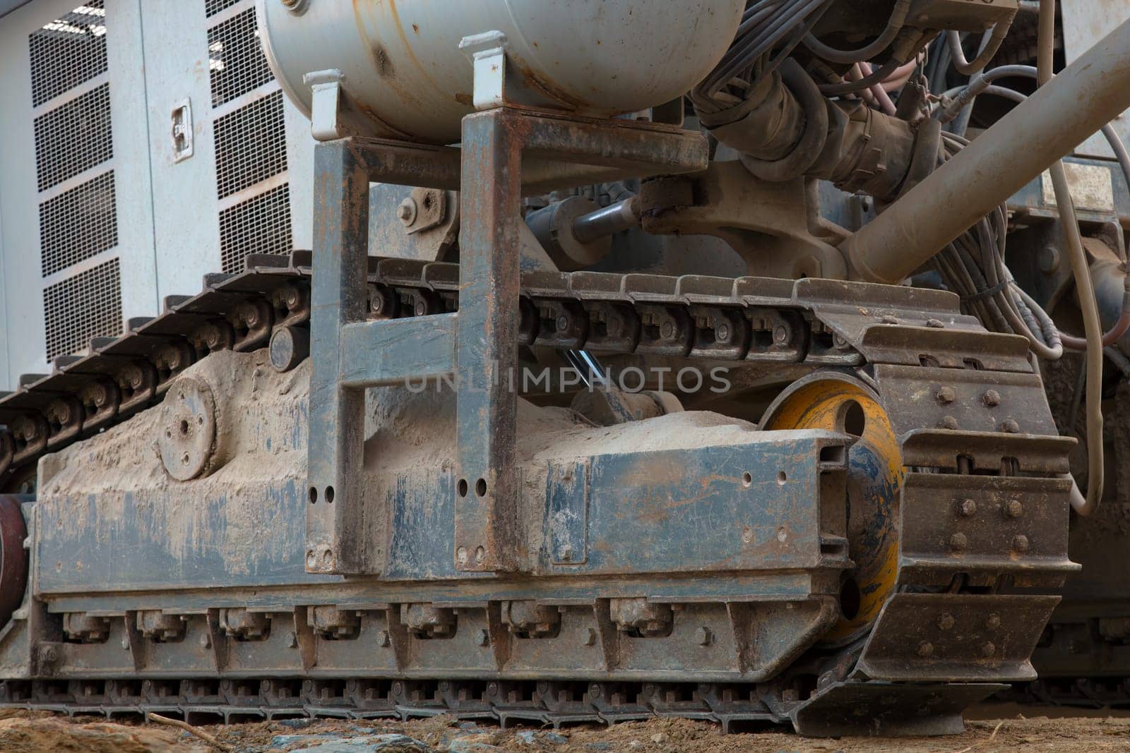 A heavy-duty hydraulic drill is hard at work on a construction site. Close up of digging machine.