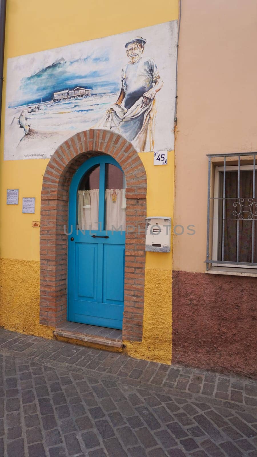 Rimini, Italy - June 25, 2024: Mural on wall at Borgo San Giuliano typical street with low and colorful houses at Rimini, Italy