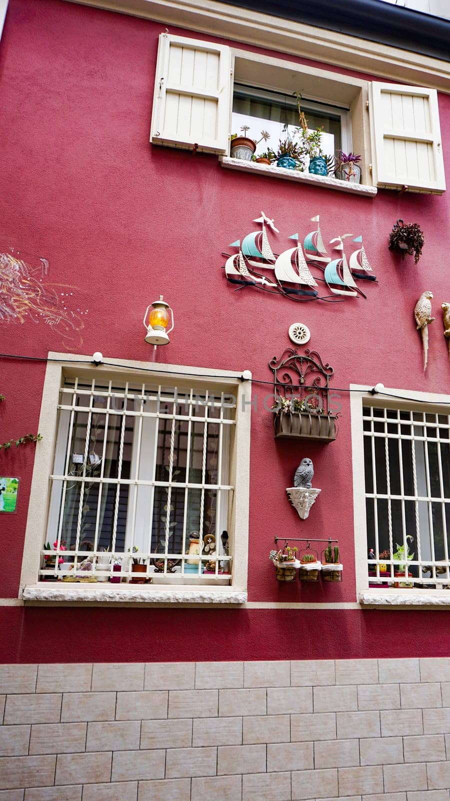 Rimini, Italy - June 25, 2024: Art installation on wall at Borgo San Giuliano typical street with low and colorful houses at Rimini, Italy