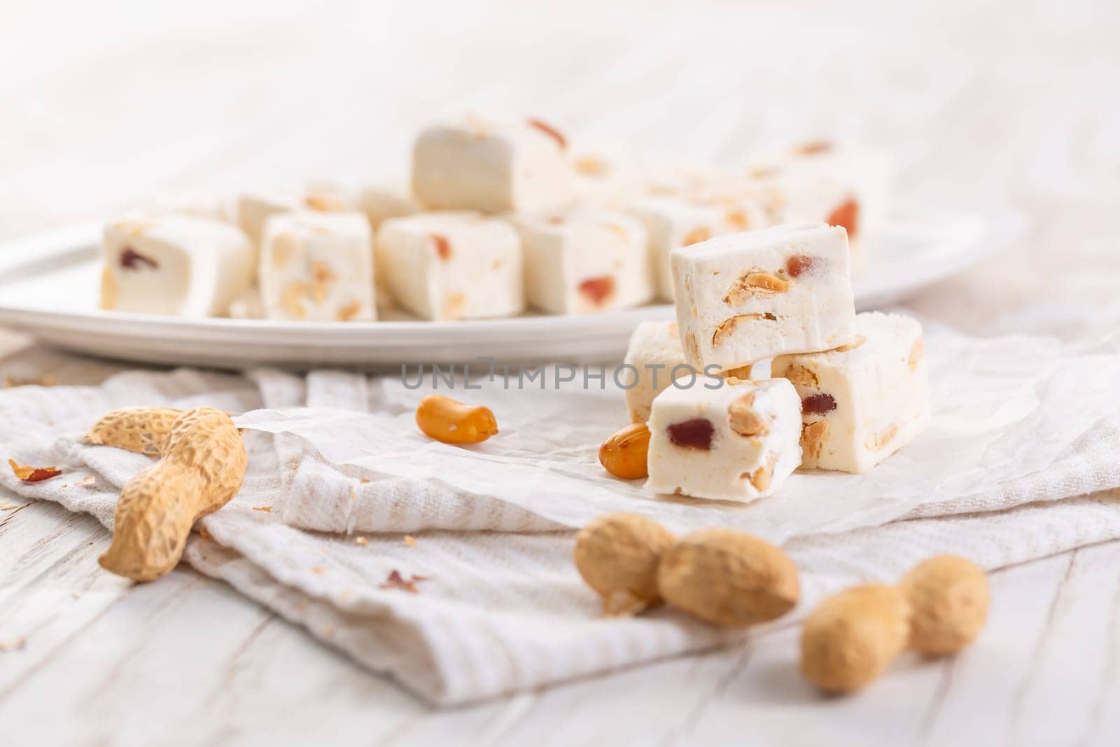 Soft nougat with peanuts on a plate, chewy sweets  with nuts