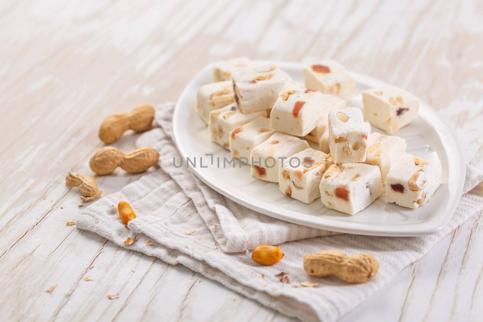 Soft nougat with peanuts on a plate, chewy sweets  with nuts