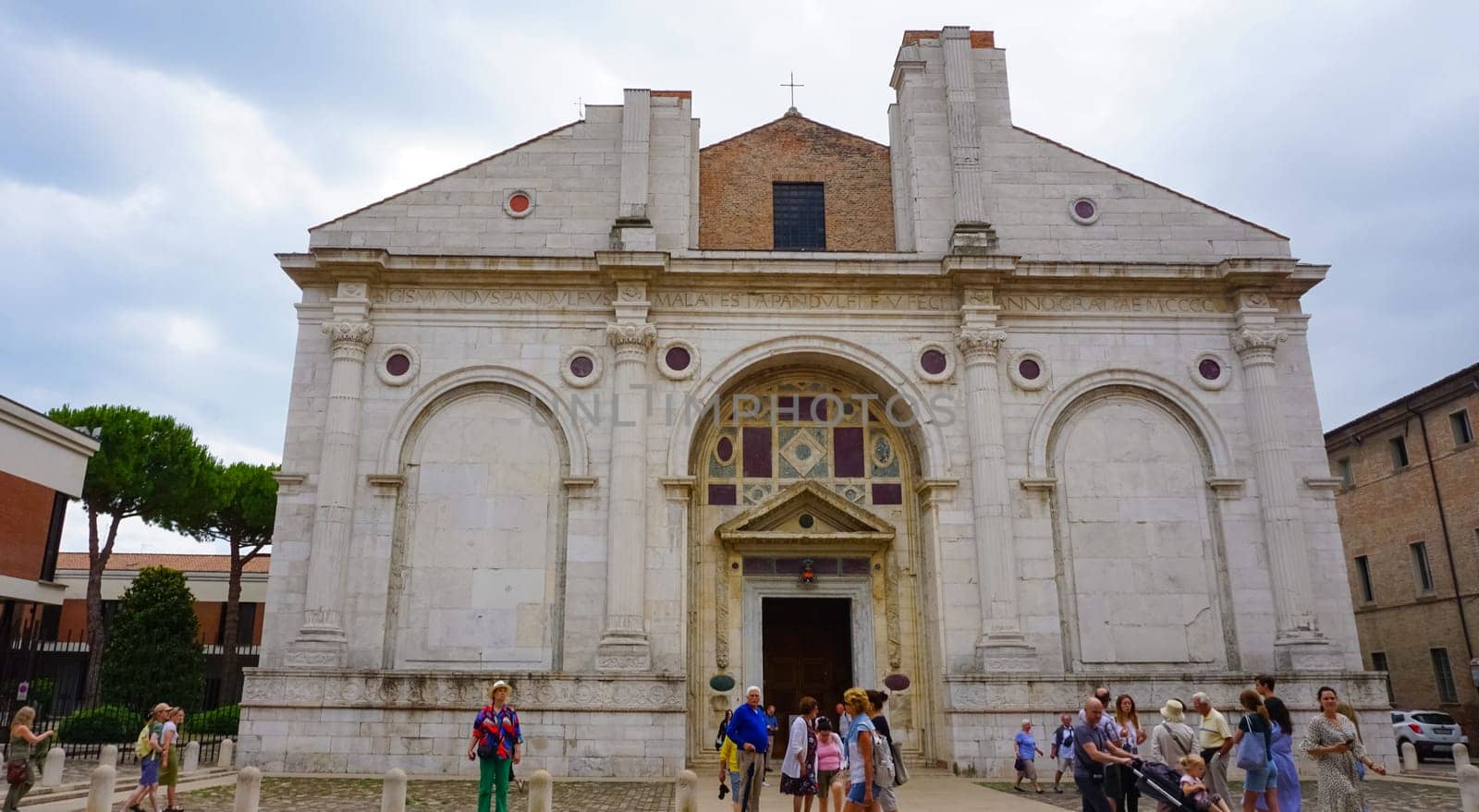 Rimini, Italy - June 25, 2024: The people going near Tempio Malatestiano or IItalian Malatesta Temple is the cathedral church of Rimini, Italy.
