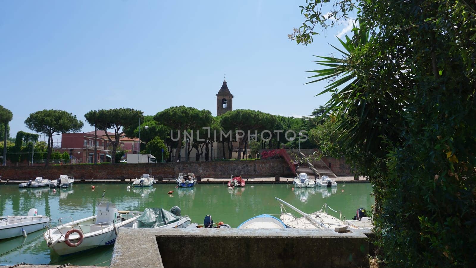 Summer view of pier with ships, yachts and other boats with ferris wheel in Rimini, Italy.