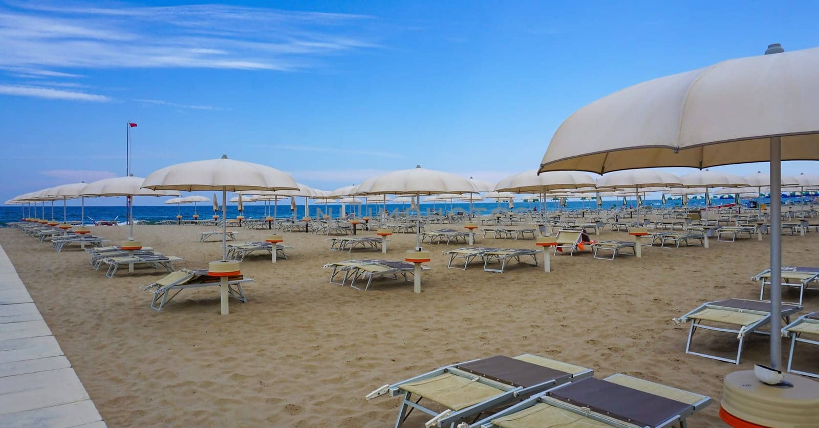 Summer. The sunbeds and parasols on the empty beach