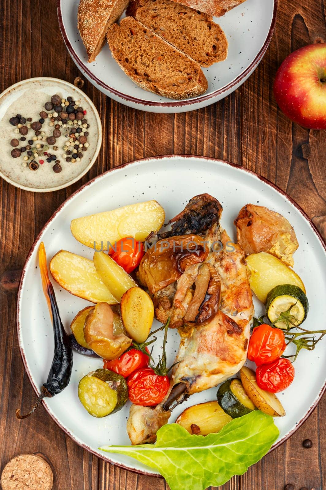 Juicy chicken meat baked with potatoes on a plate. Homemade chicken legs. Oven baked food