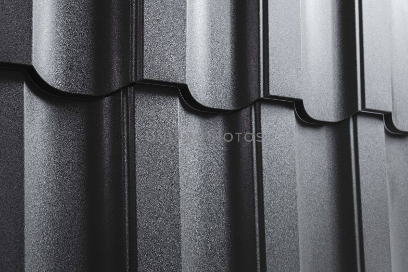 Close-up view modular tile effect roof panel. Lightweight galvanised steel roofing sheet. Traditional metal shingle tiles. Popular profiled metallic pantile mimic clay or concrete slate
