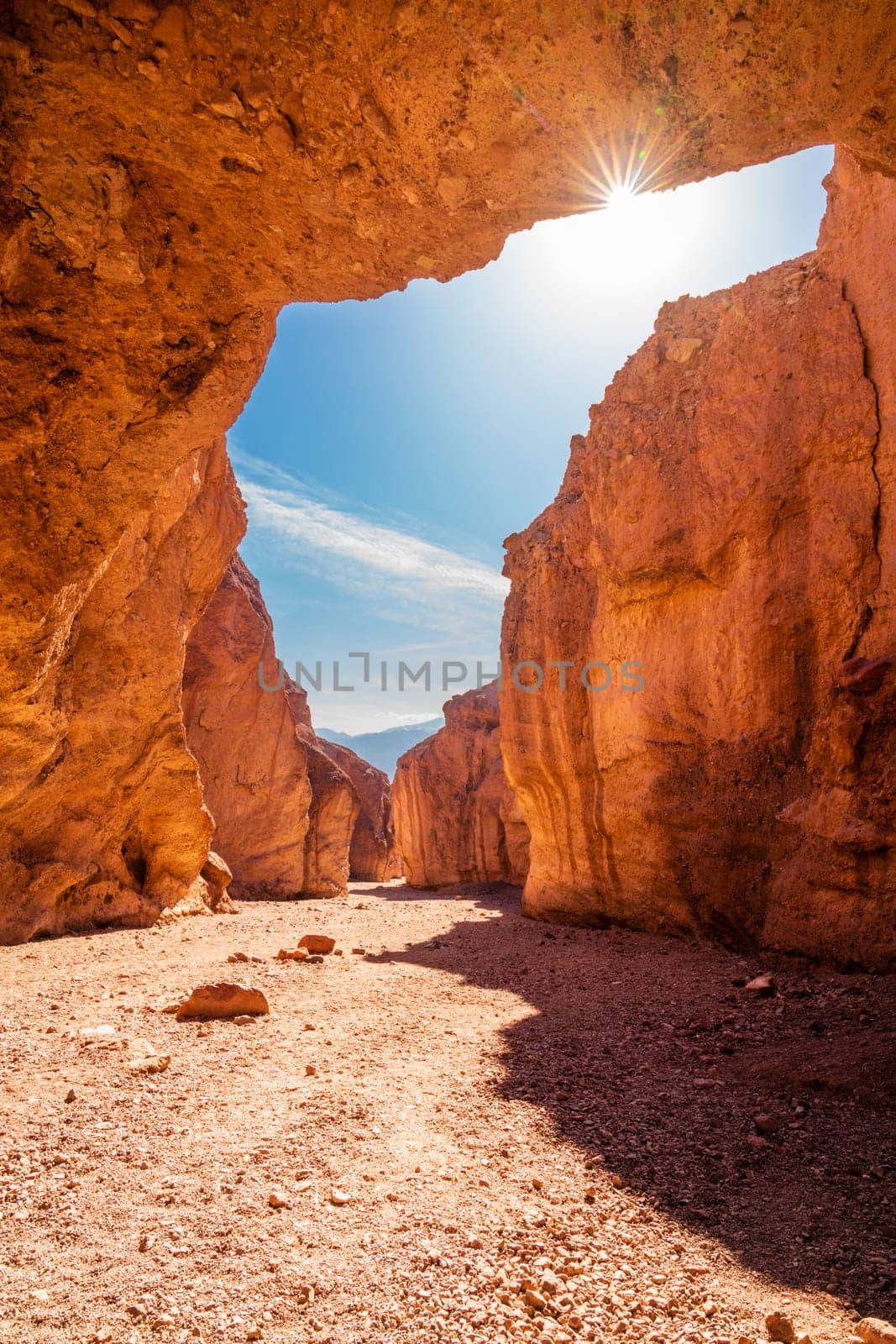 Sun peaking through the roof of the Natural Bridge rock formation in Death Vallley National Park in California