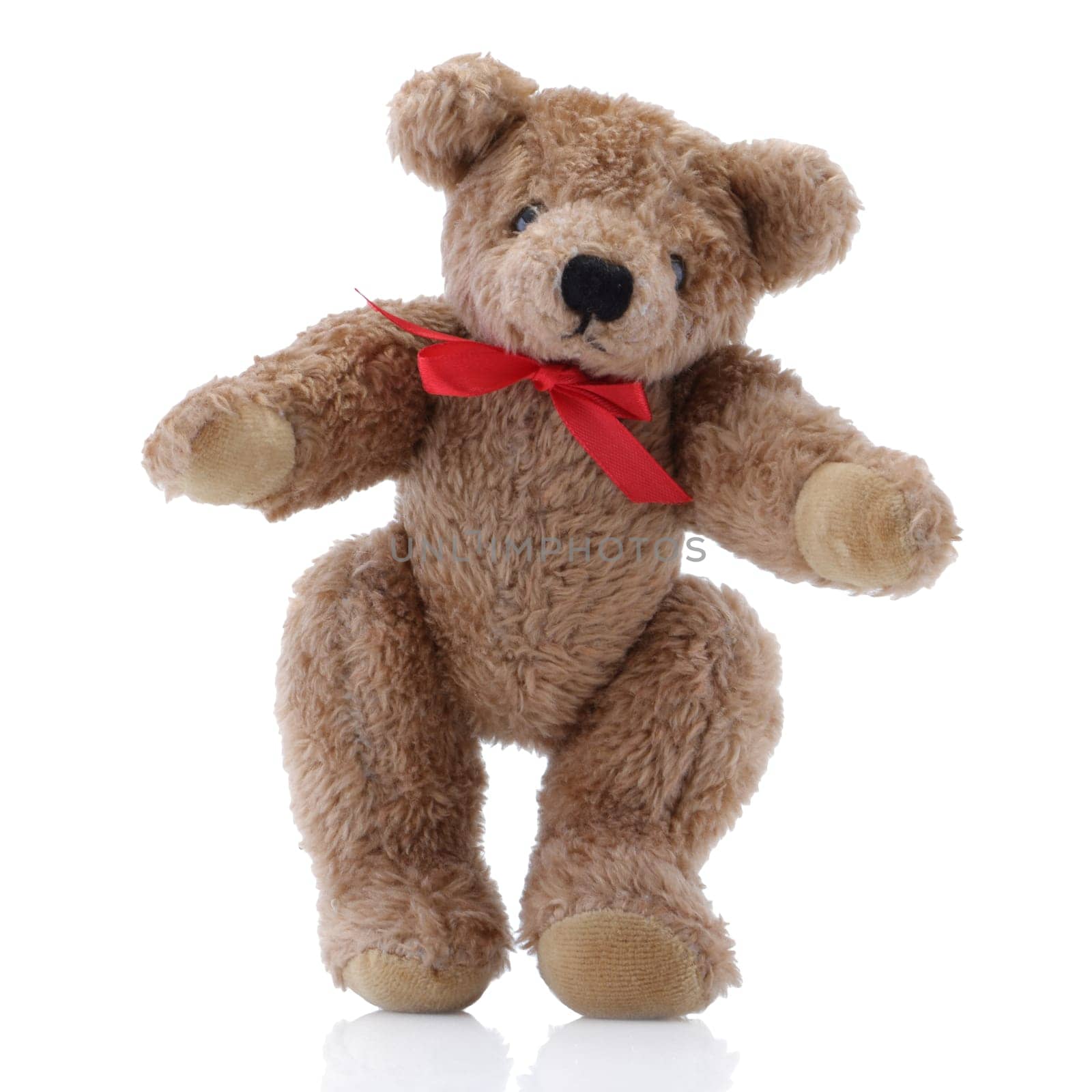 A Brown Teddy Bear with a red bow standing up