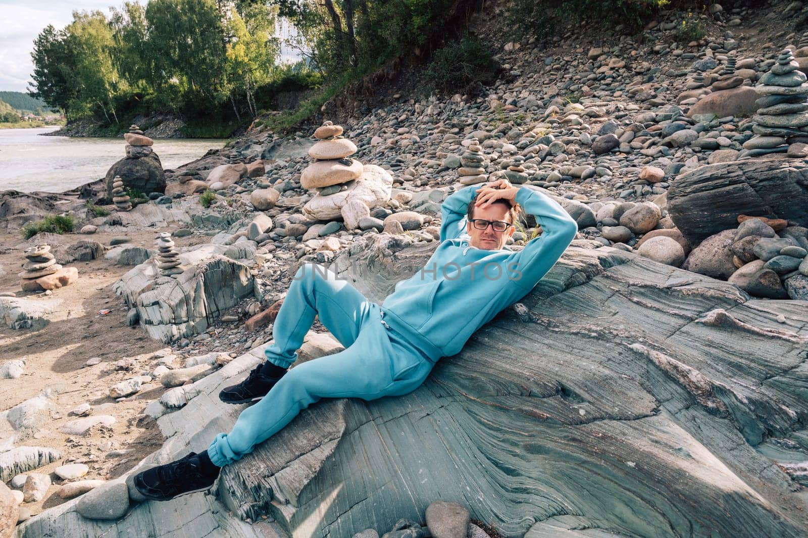 Man at the river Katun at summer day. Trip on Altai Mountains in Altai Republic