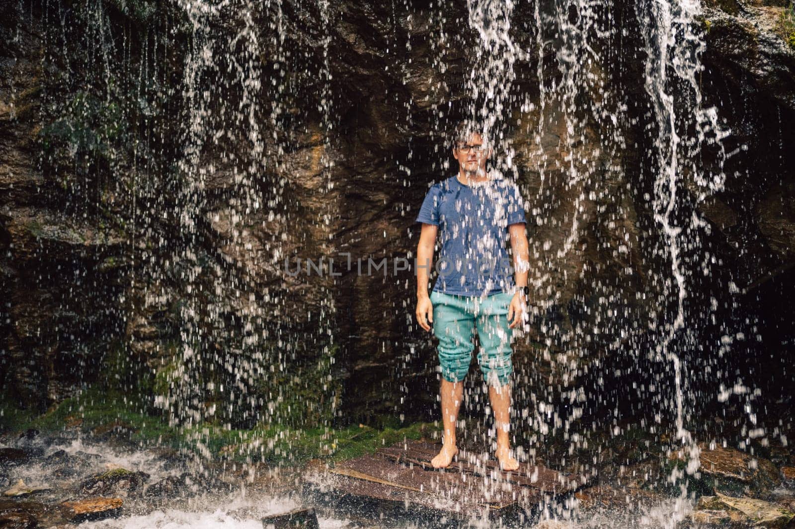 Man at waterfall in summer Altai Mountains.