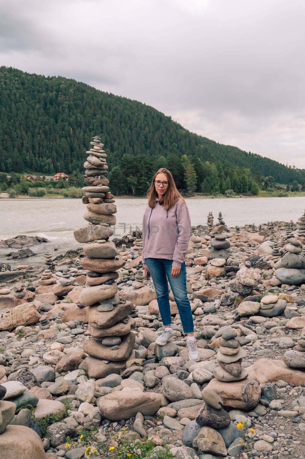 Woman at the river Katun at summer day. Trip on Altai Mountains in Altai Republic
