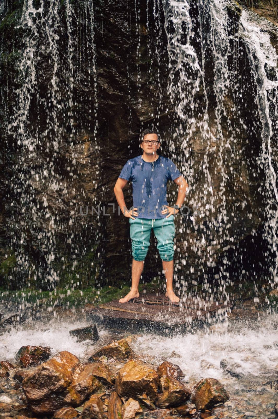 Man at waterfall in summer Altai Mountains.