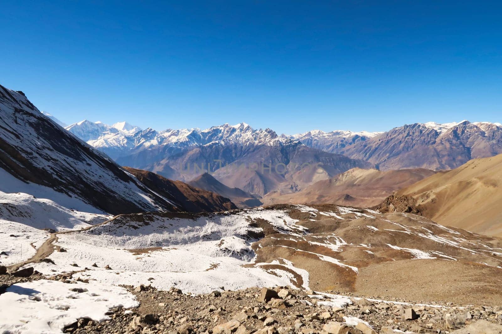 View from the trail from the Thorong La, Thorung La, Thorang La pass to Muktinath, a small ridge in front of a mountain range, Annapurna Circuit Trek, Nepal 2022