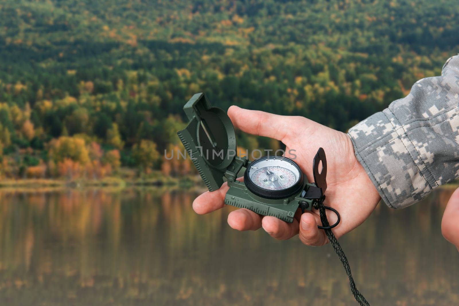 Man with compass in hand n Altai mountains. Travel concept.