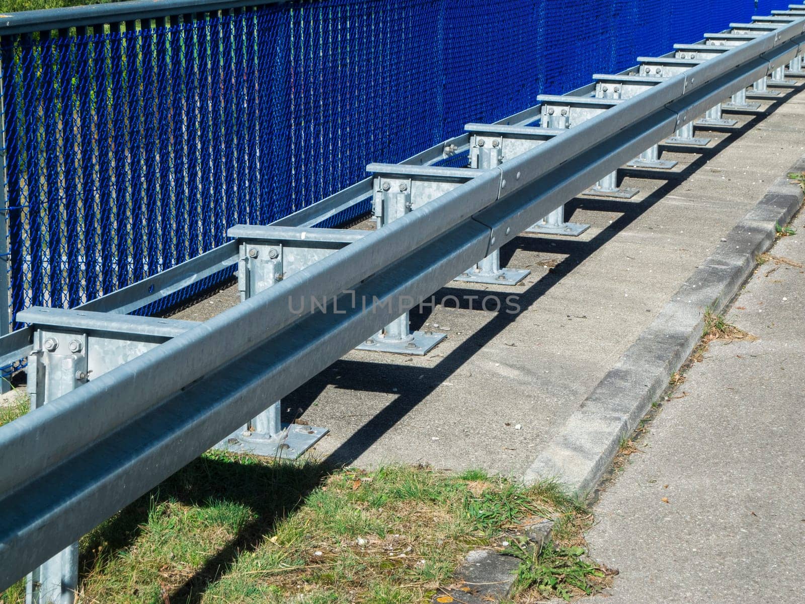 Partial perspective view of the railing with guard rails installed in front of it on a motorway bridge in summer in Bavaria.