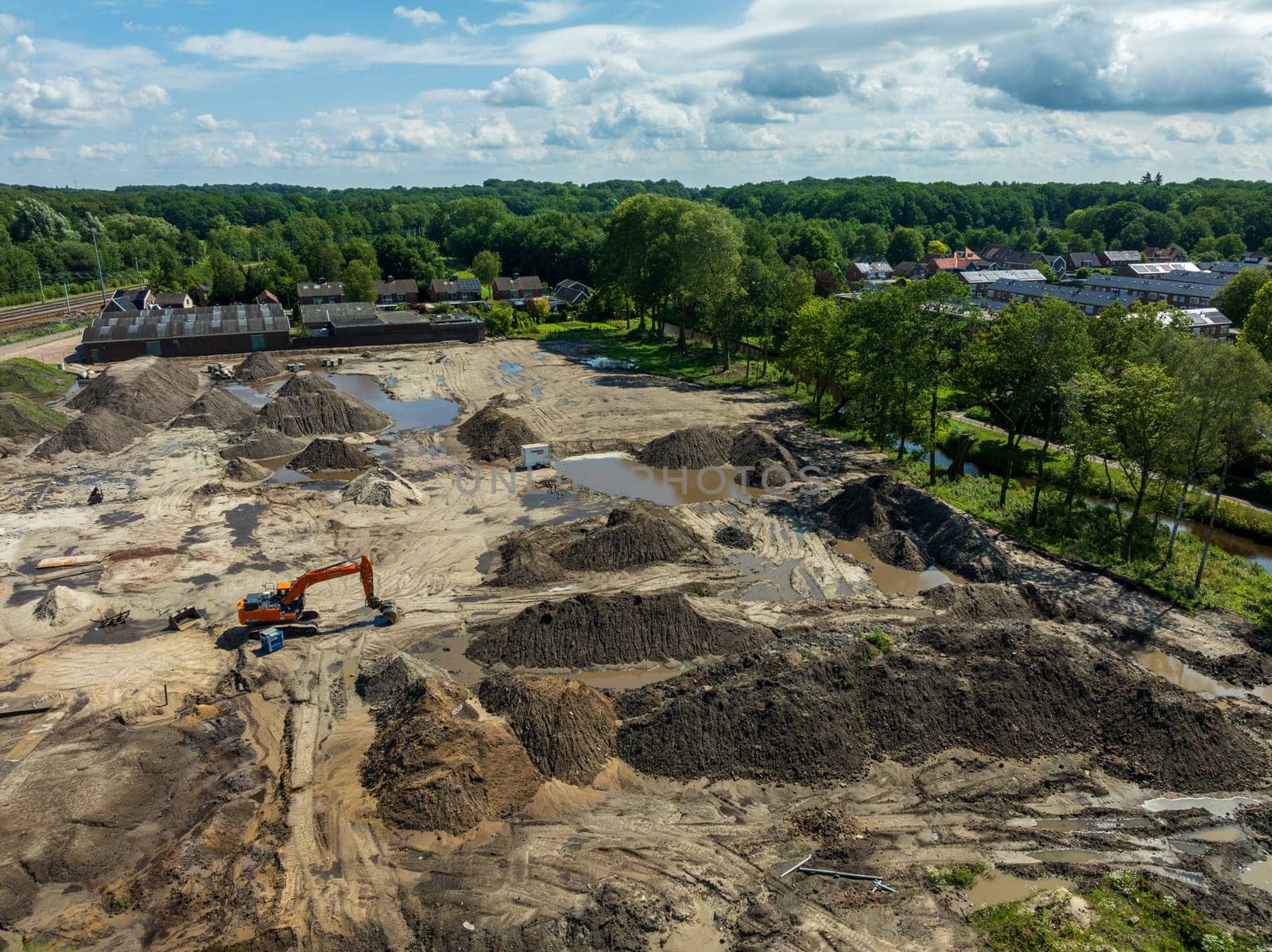OLDENZAAL, NETHERLANDS - JULY 14, 2024: EAerial view on an excavator on an empty construction site