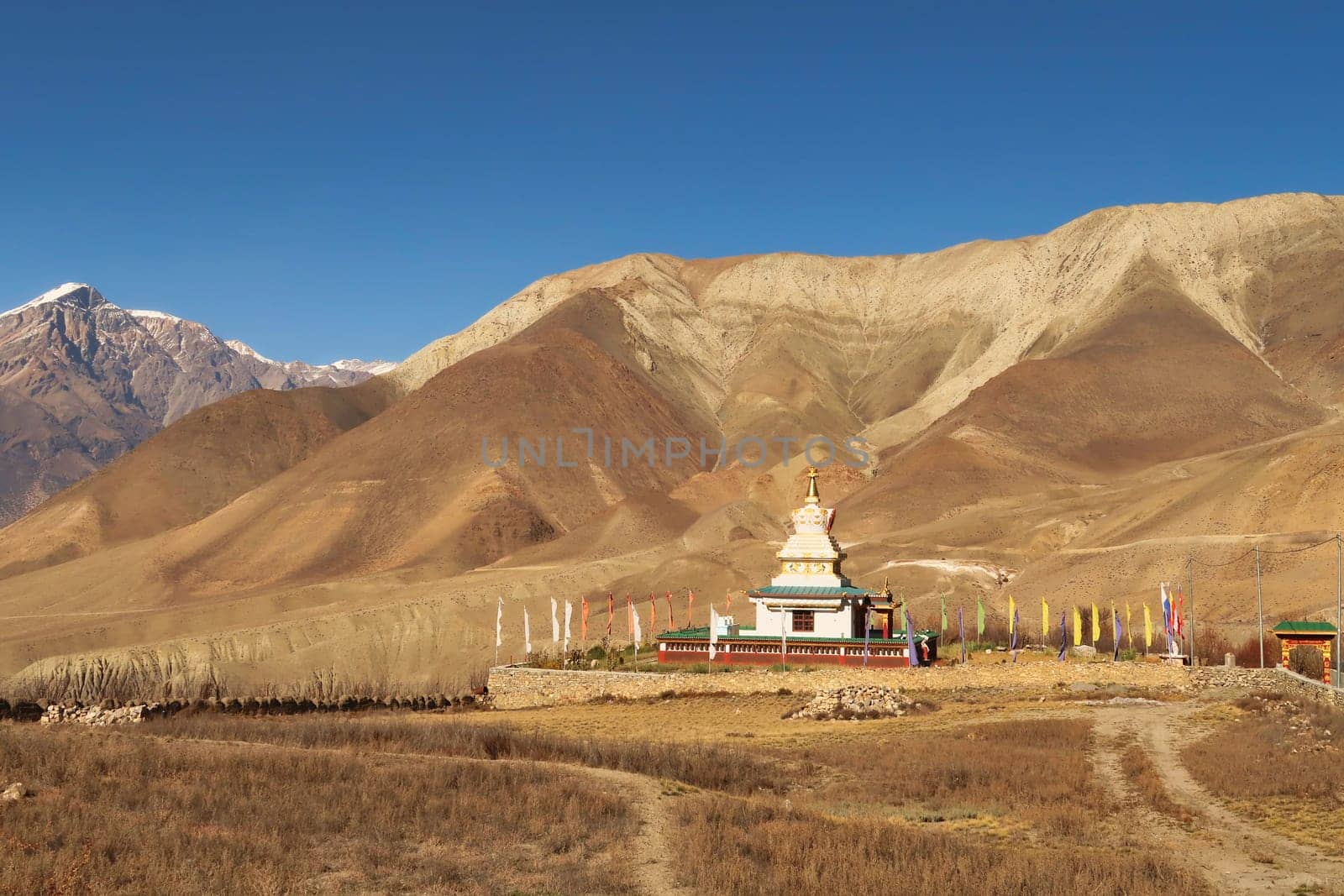View onto Jangchup Choeten, a buddhist temple, pagoda, stupa in the dry landscape between Muktinath, Ranipauwa and Kagbeni, Annapurna Circuit Trek, Nepal 2022