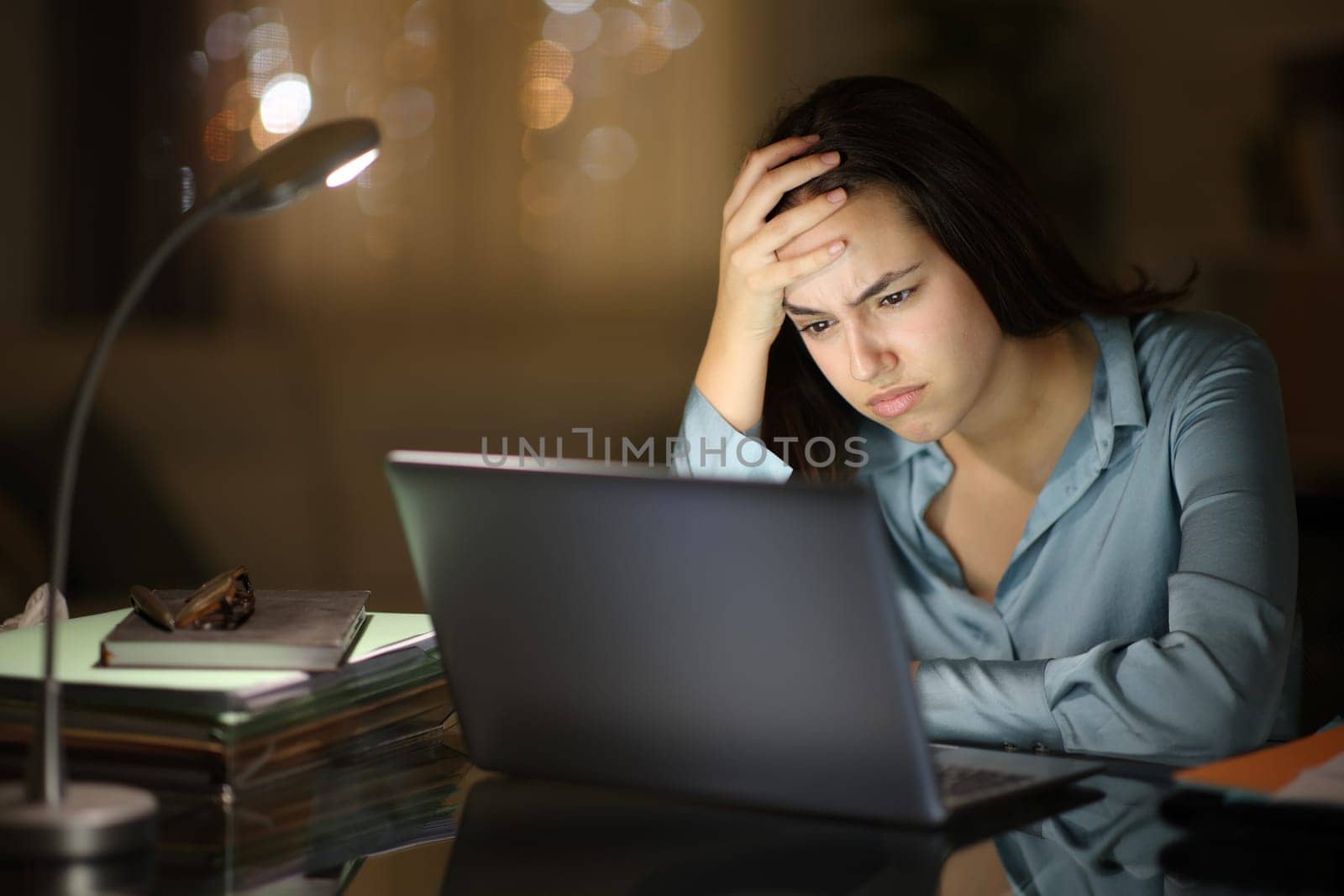 Frustrated businesswoman working online with a laptop in the night at home