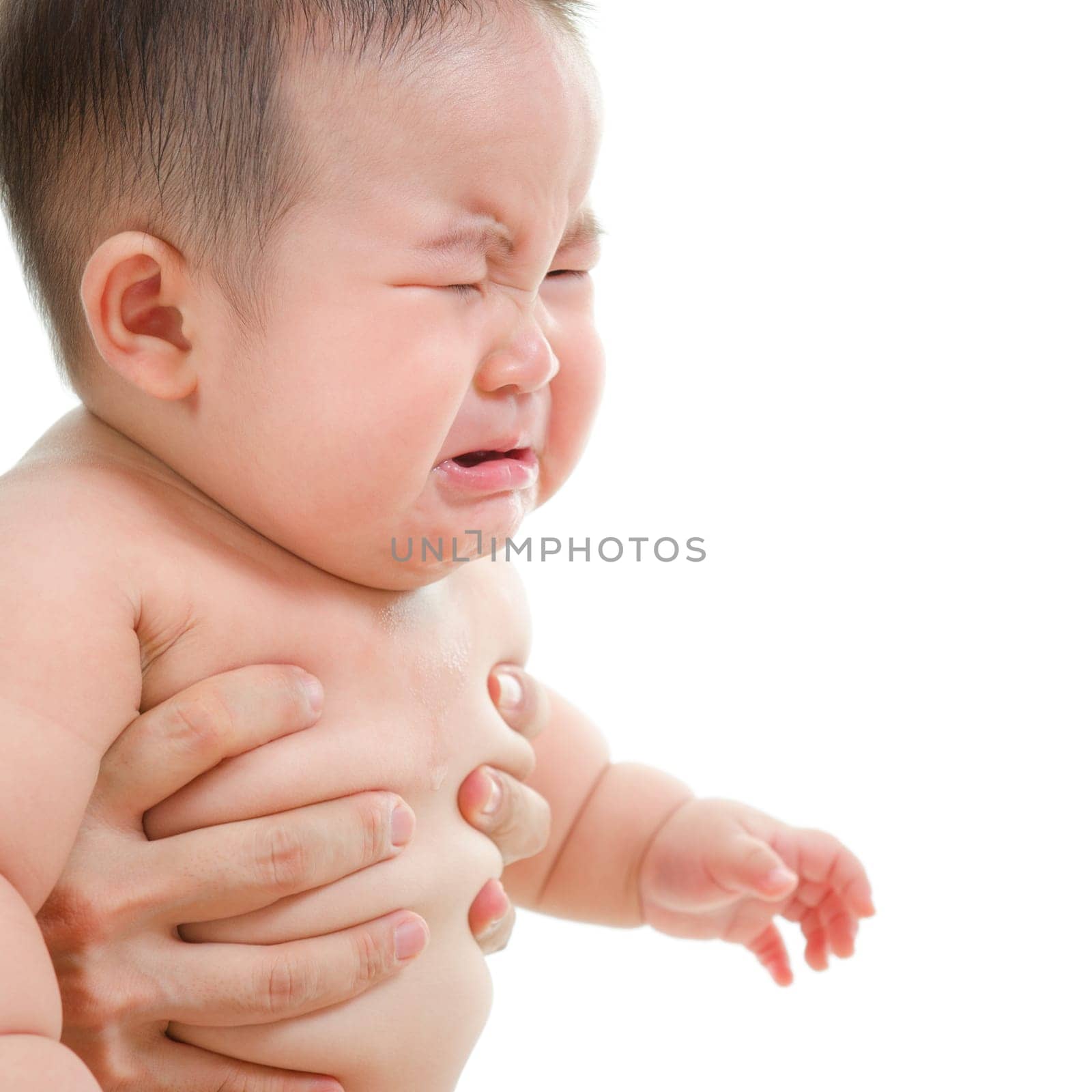 Sad Asian baby boy crying, sitting isolated on white background