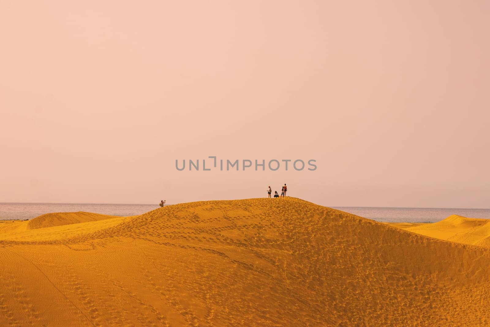 Gran Canaria, Spain, Canary Islands, Playa del Inglés - Jul 17, 2024. Tourists walking in the fine sand dunes of Maspalomas. Maspalomas Dunes Nature Reserve.