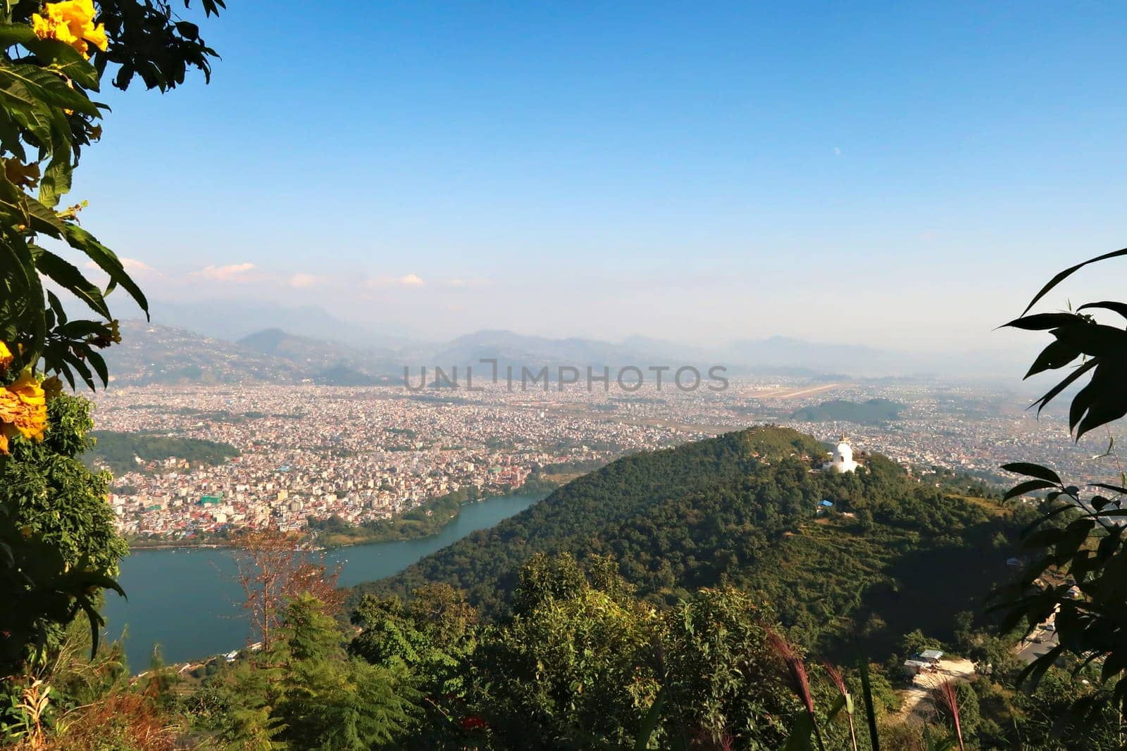 View onto the World Peace Pagoda in front ot the town of Pokhara at the shore of Phewa Lake, on the way up to the shiva statue at the Pumdikot Religious Area, Nepal 2022