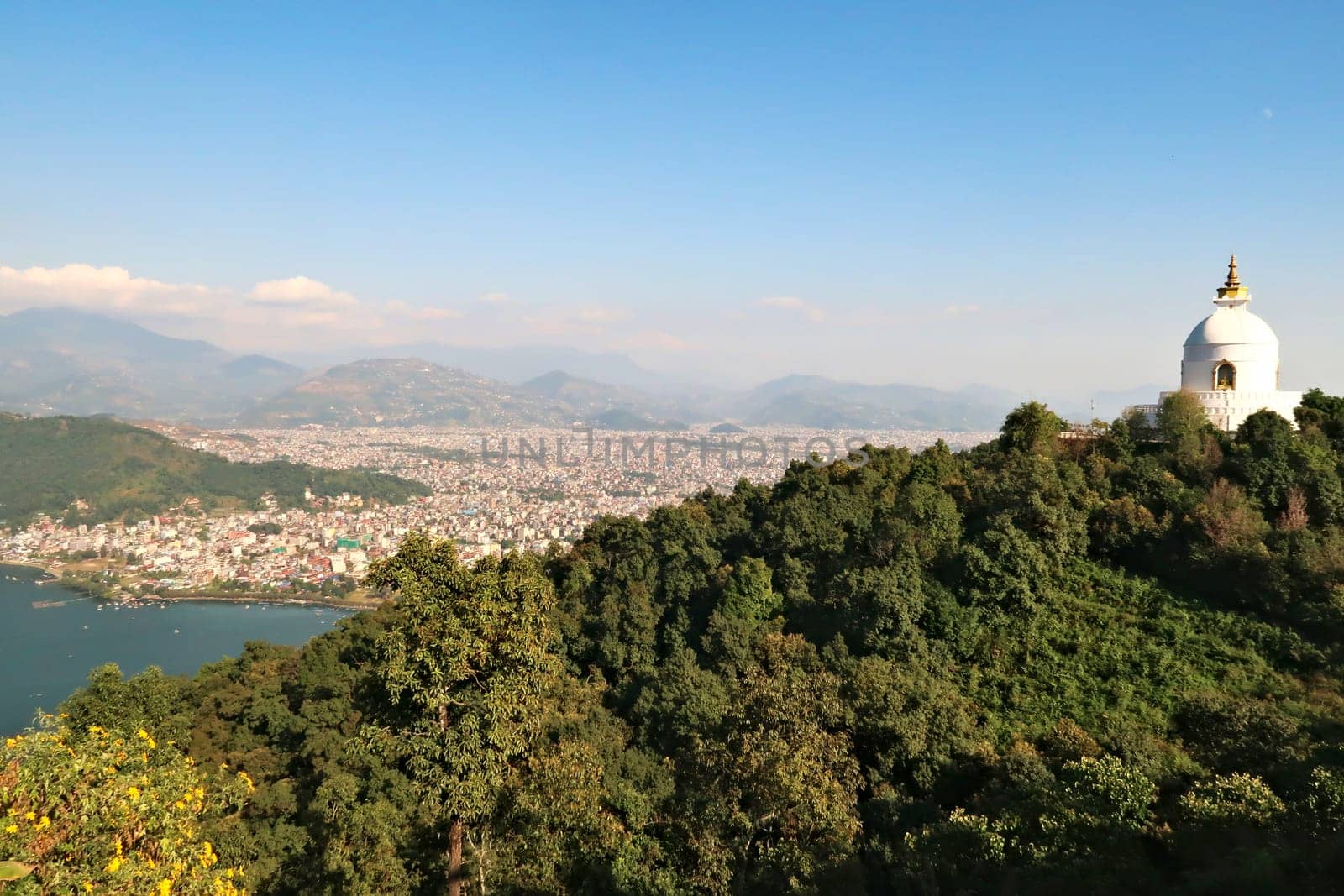 View onto the World Peace Pagoda in front ot the town of Pokhara at Phewa Lake, on the way up to the shiva statue at the Pumdikot Religious Area, Nepal 2022