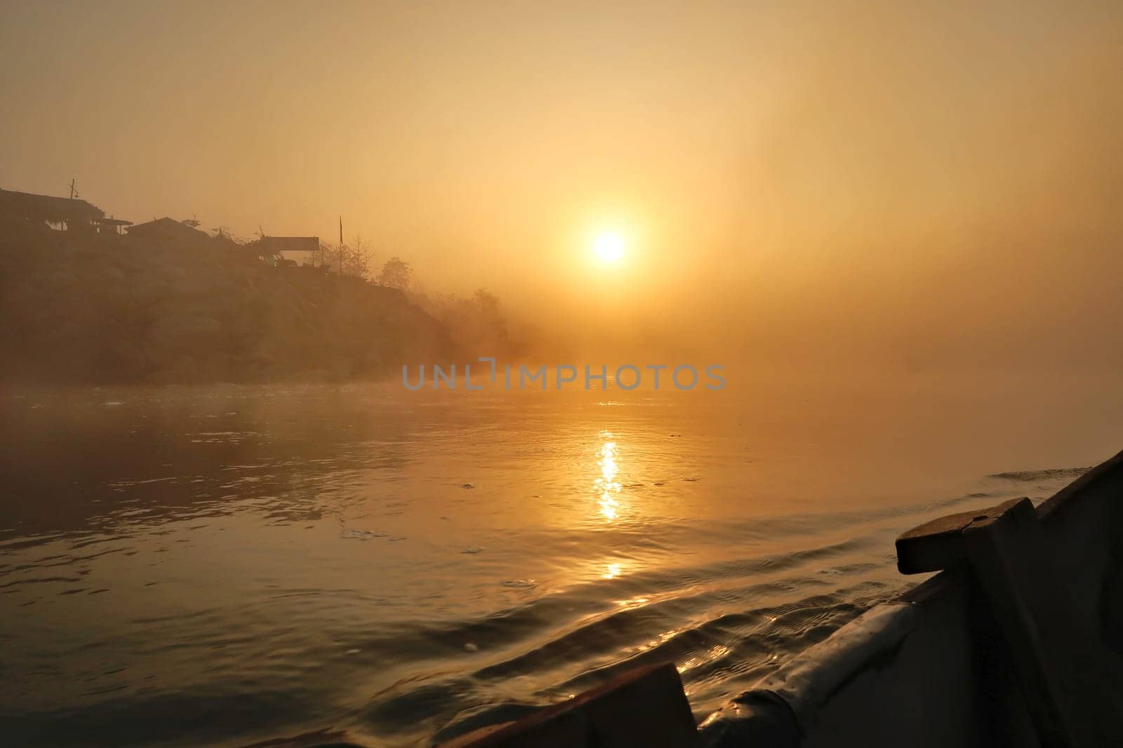 Crossing the East Rapti River at sunrise on a boat from Sauraha village to enter the Chitwan National Park, Nepal 2022