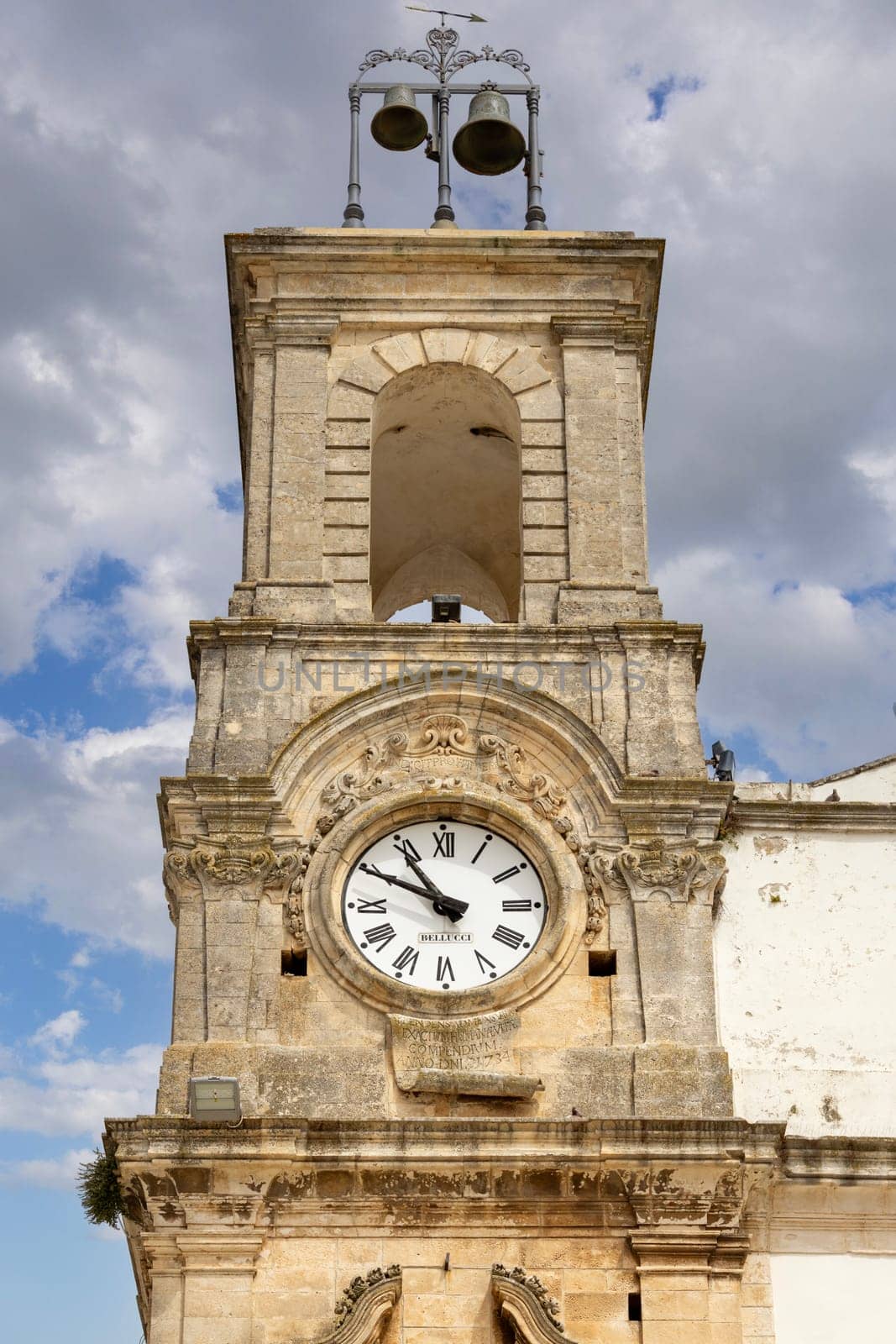 Martina Franca, Italy, Apulia - May 25, 2024: Civic Tower (Torre dell'Orologio) next to University Palace, located in Plebiscito Square (Piazza Plebiscito)