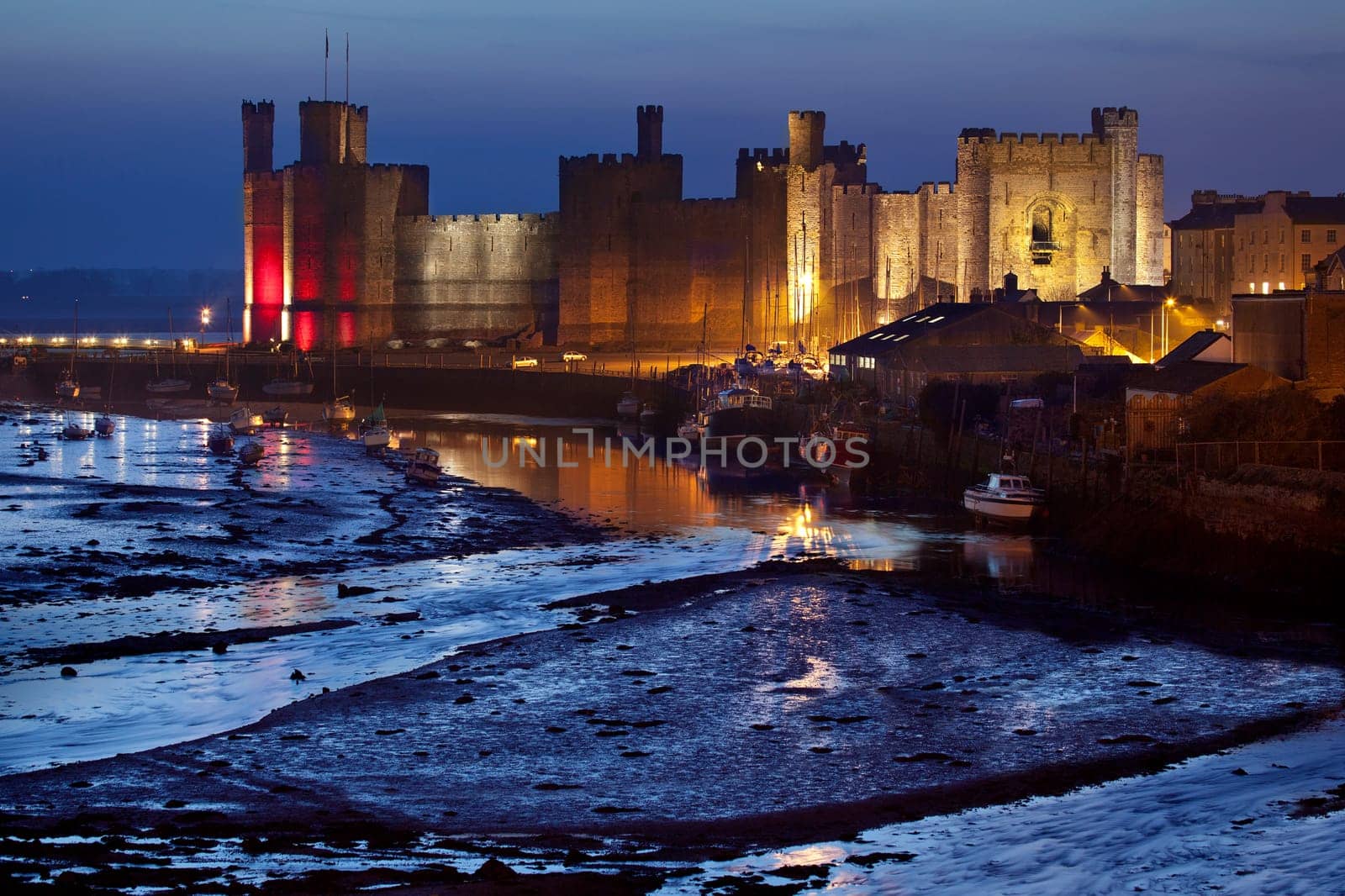Caernarfon Castle at low tide in the town of Caernarfon in Gwynedd on the north coast of Wales in the United Kingdom. Dates from 1123.