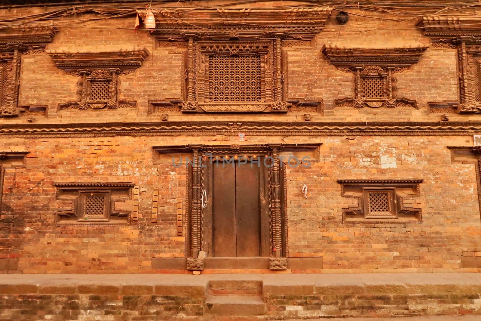 Facade of a temple, palace with elaborate wood carvings on the windows and doors in the ancient city of Bhaktapur in the Kathmandu Valley, Nepal 2022