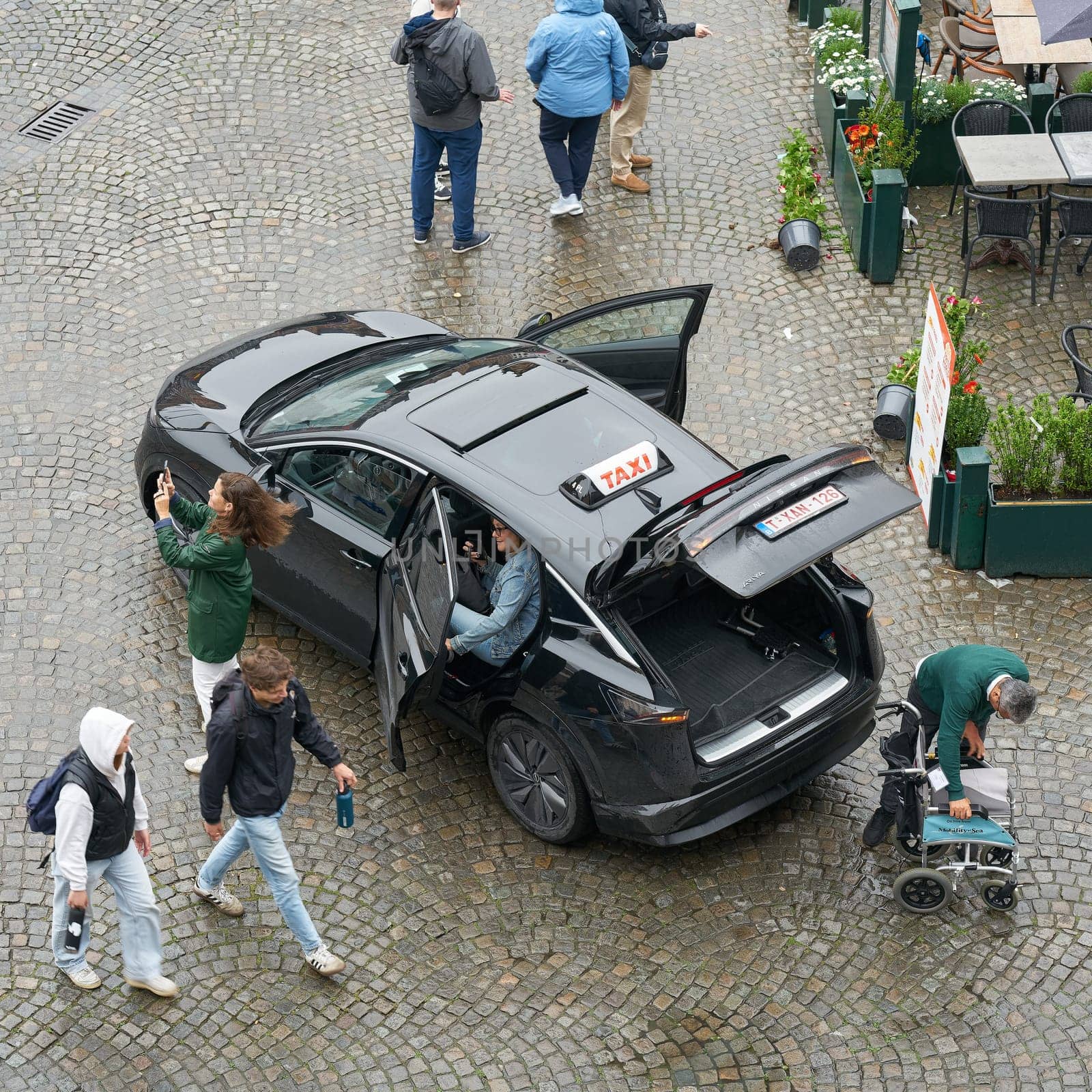 A cab arriving and passengers getting out on the market square in Bruges, Belgium