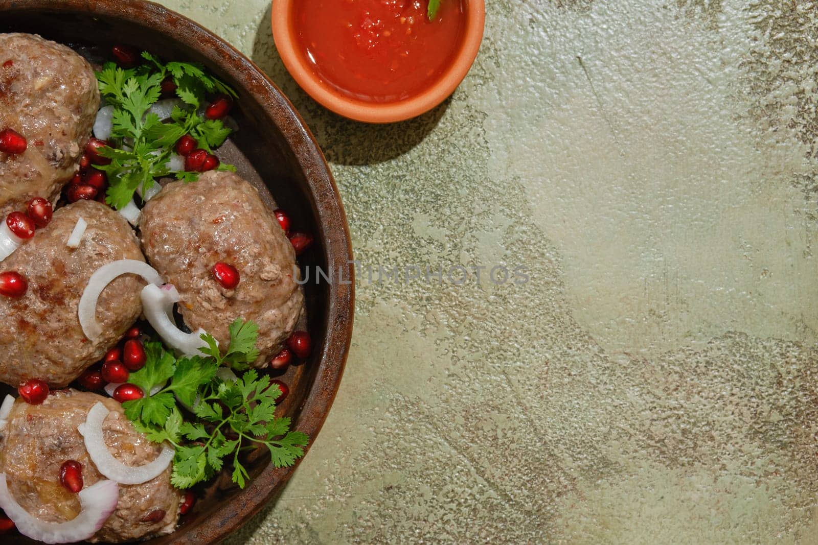 Traditional Georgian fried beef cutlets - Apkhazura in clay pot and adjika bowl with copy space