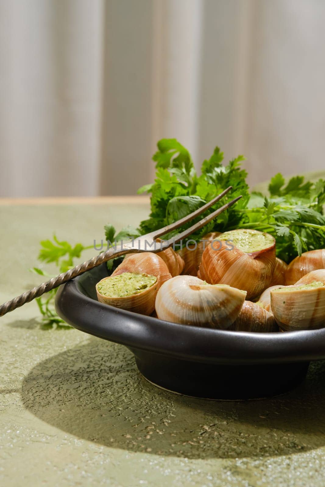 French gourmet food - Escargot snails baked in sauce on a plate