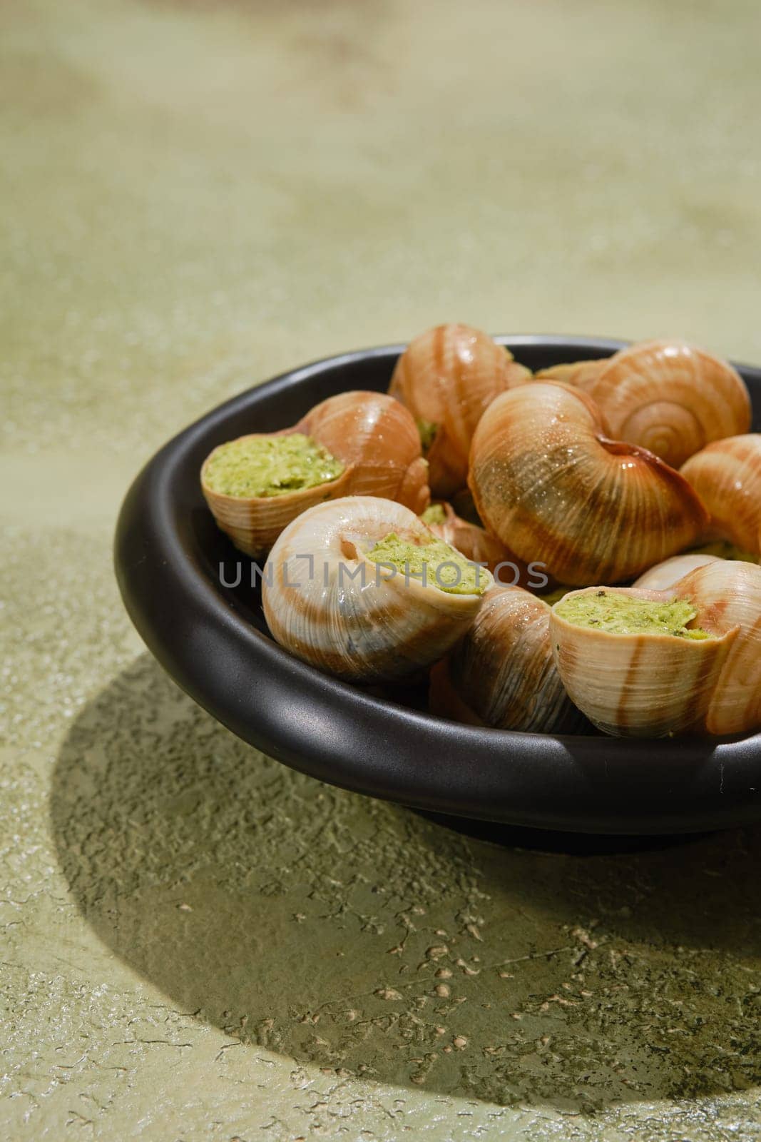 Close-up view of Escargot snails stuffed with butter, spice and cilantro