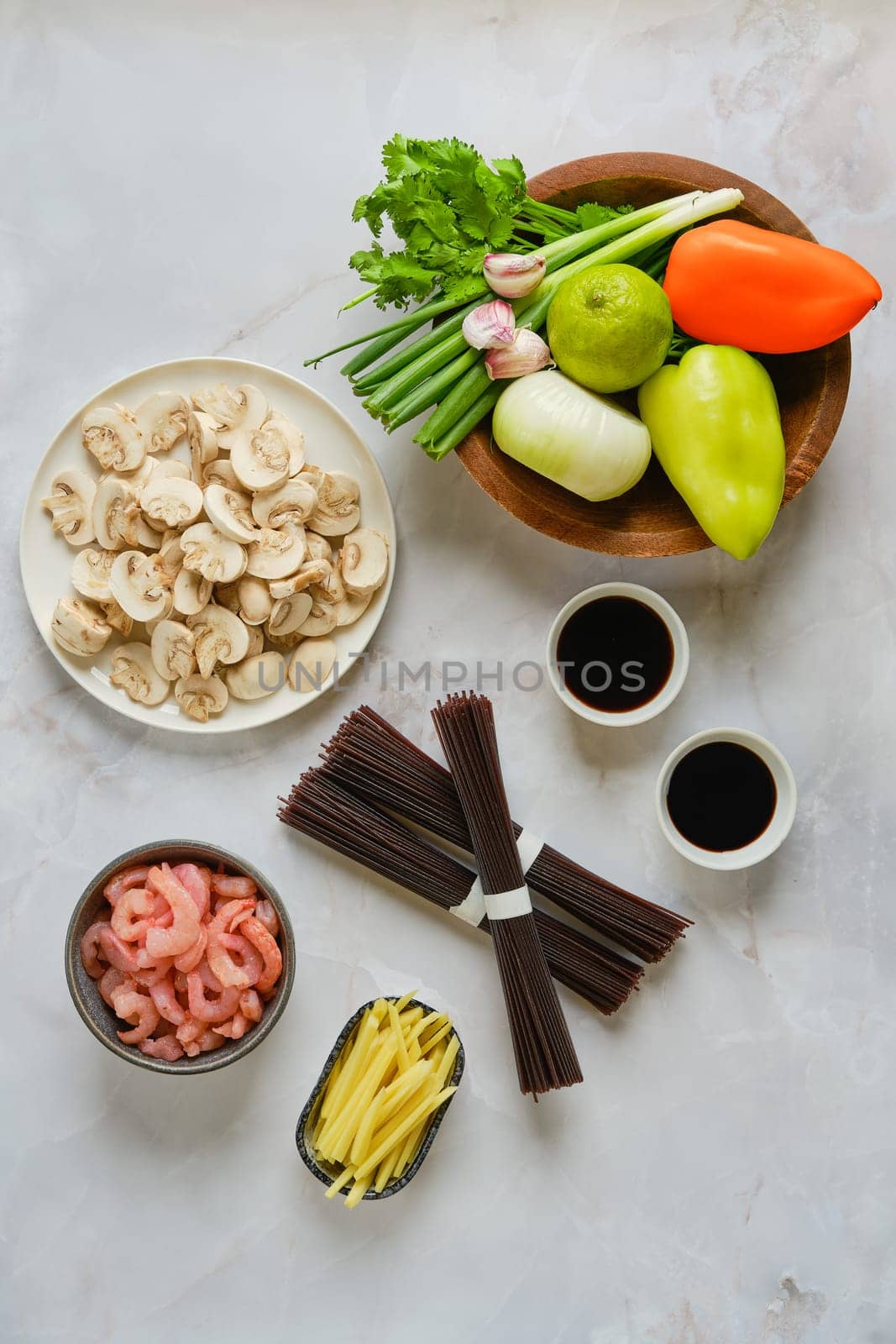 Overhead view of marble tabletop with ingredients for spicy black rice noodles
