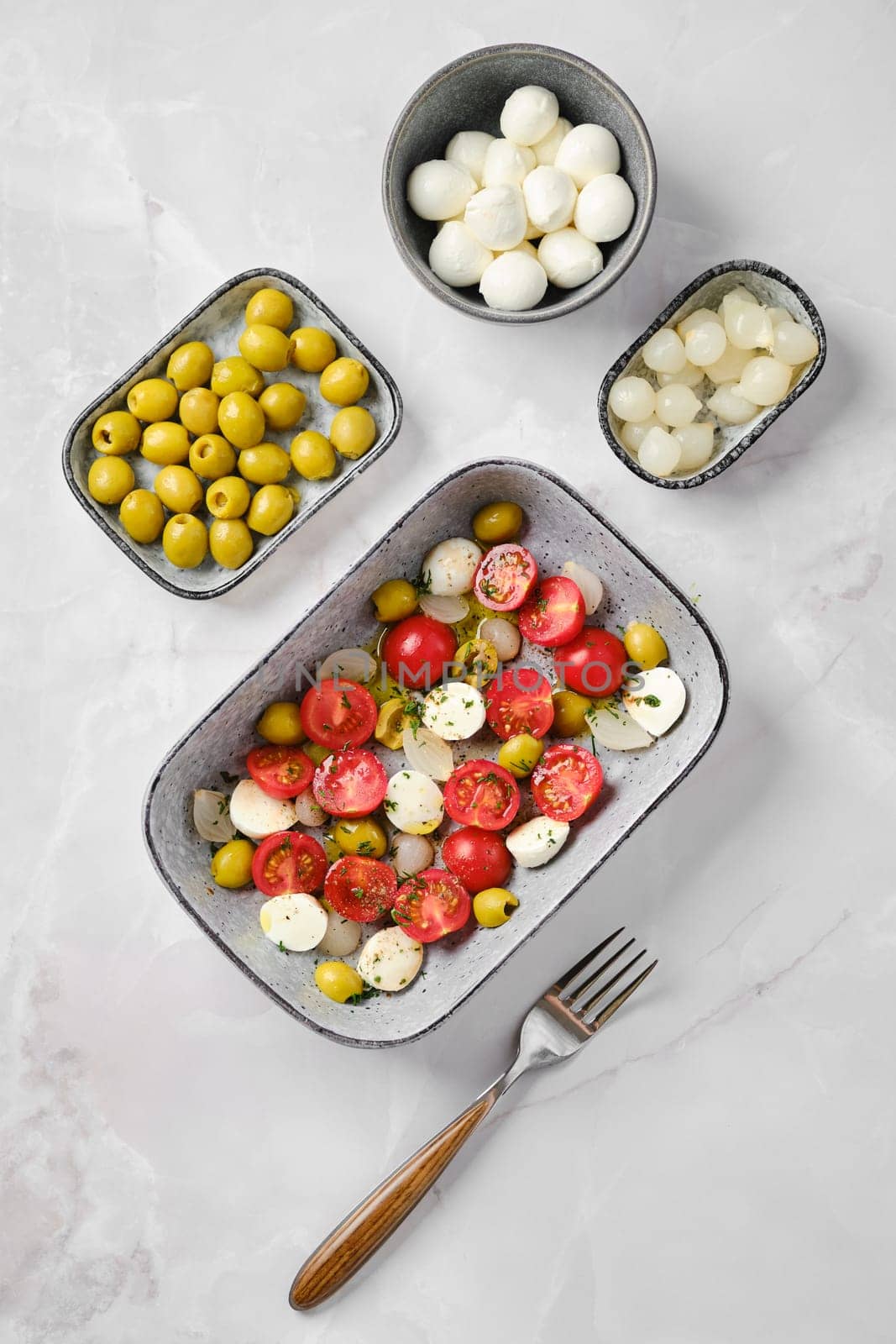 Overhead view of caprese salad seasoned with olive oil and balsamic vinegar