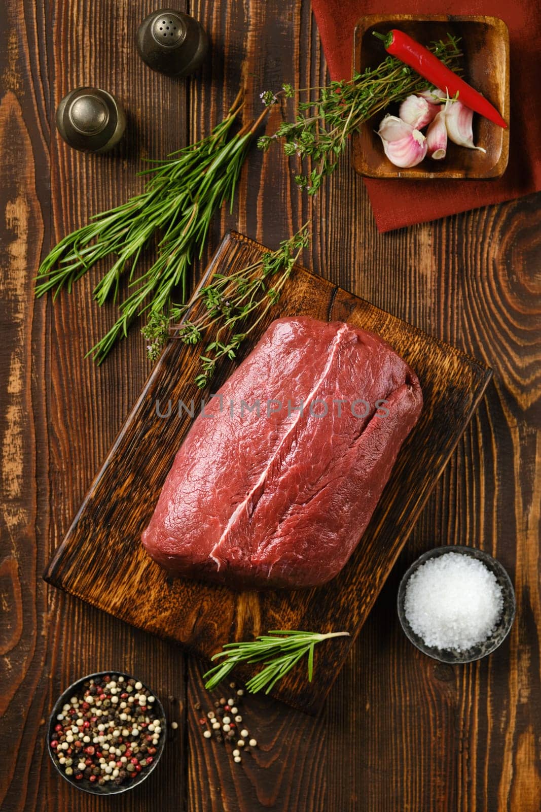 Close-up view of raw fresh beef flat iron steak on wooden kitchen table