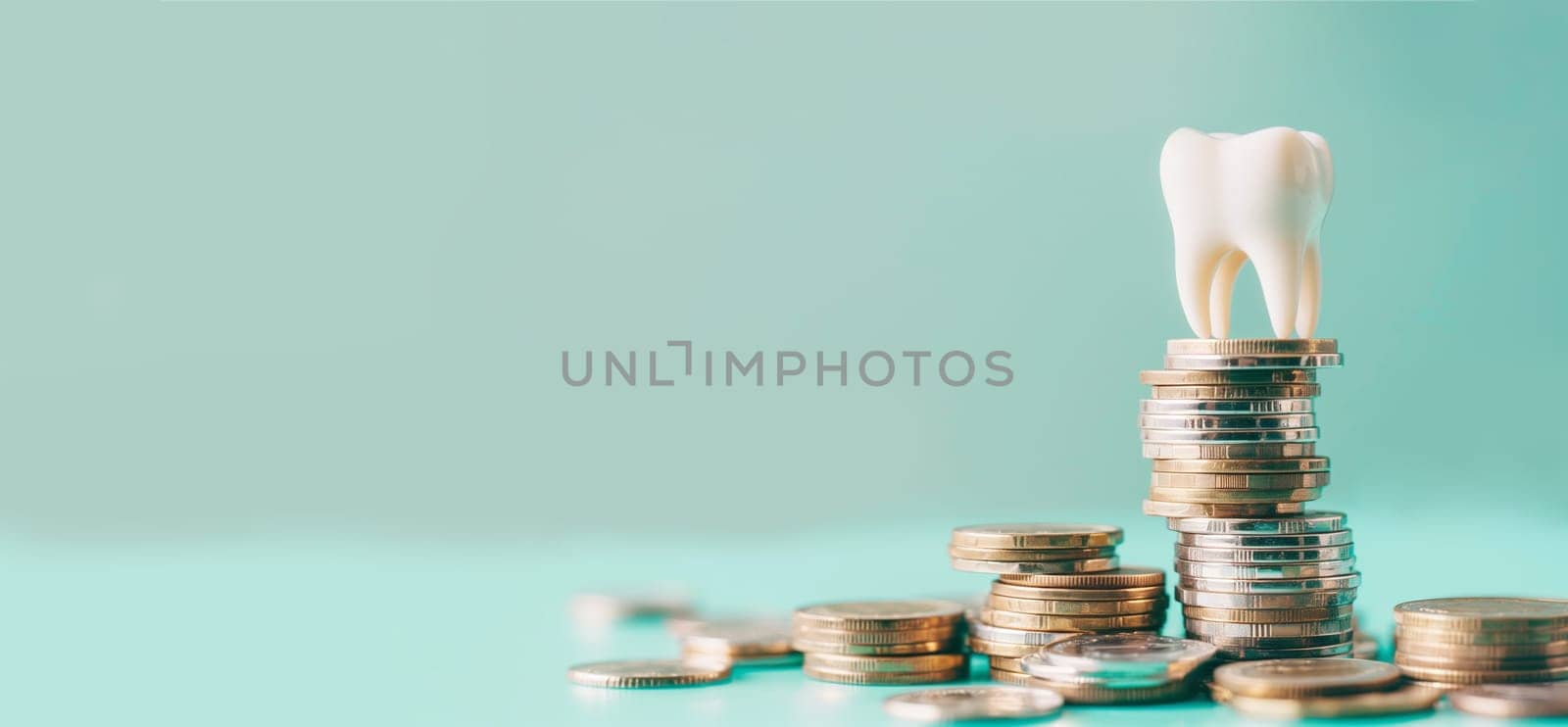 Tooth on a pile of money coins, medical care and insurance concept, paying for dental treatment, fillings, dentures and prostheses