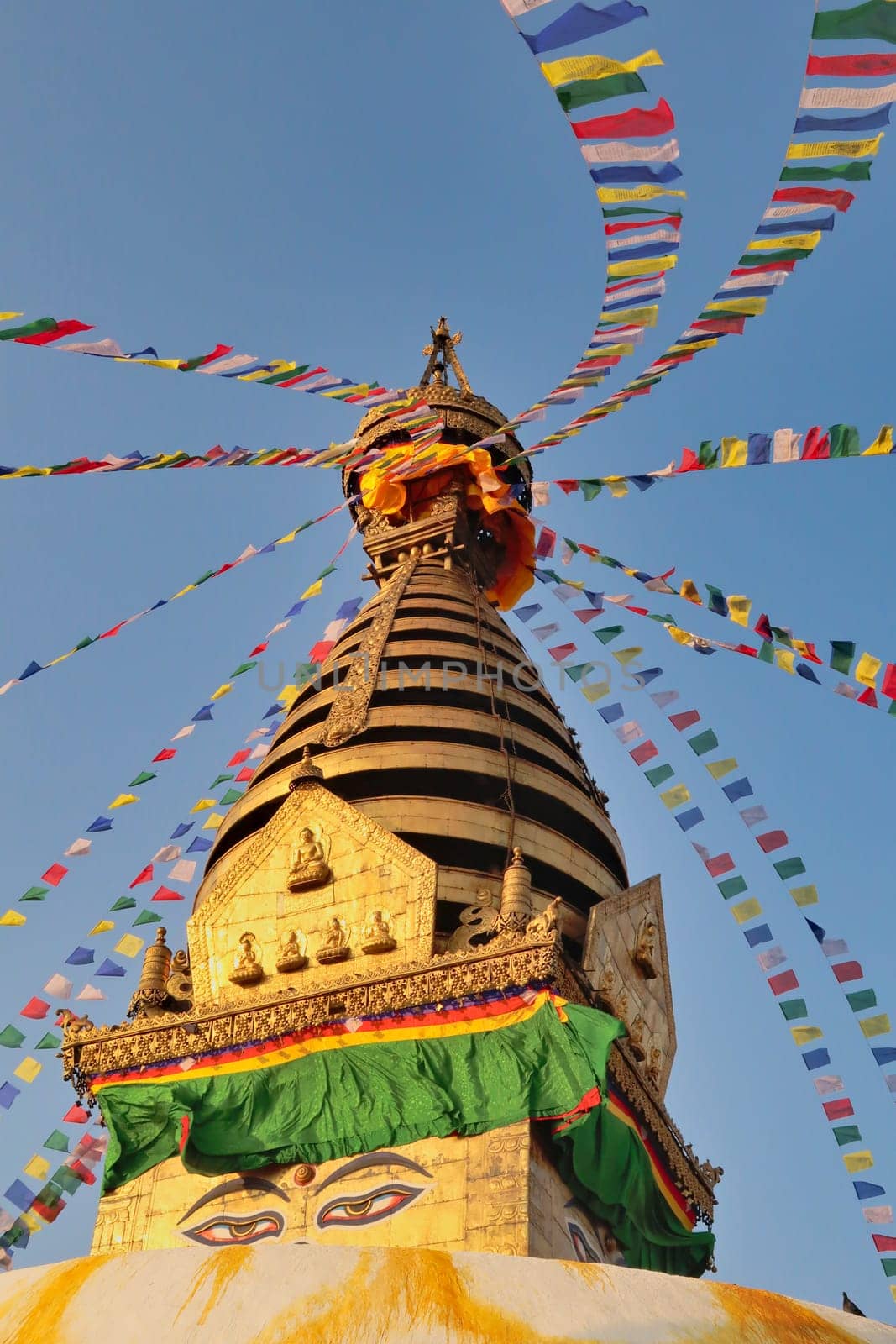 Many colorful prayer flags are attached to the golden top of the Swayambhunath Stupa, Temple with a face on it, Kathmandu, Nepal 2022