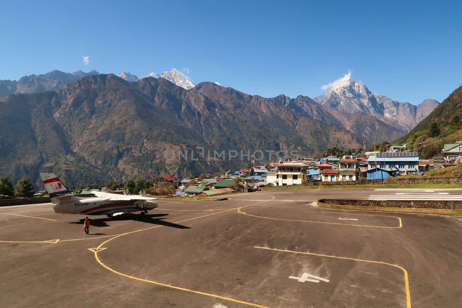 The airfield, landing field of the Hillary-Tenzing Airport, Lukla Airport, a small plane, aircraft is waiting for take off, Kongde Ri peak in the background, Mount Everest Base Camp Trek, EBC, Nepal 2022