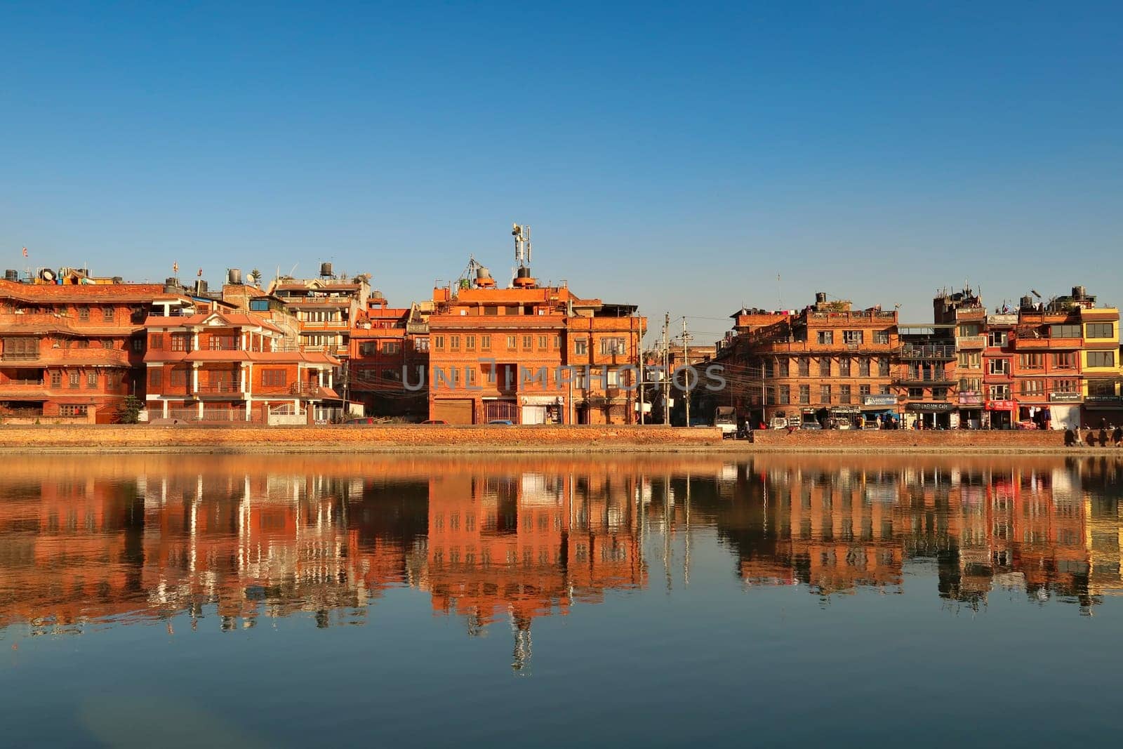 At the Na Pukhu Lake, Pond in Bhaktapur, apartment, residential houses, buildings, dwellings are reflecting perfectly in the smooth surface of the water, Bhaktapur, Nepal 2022