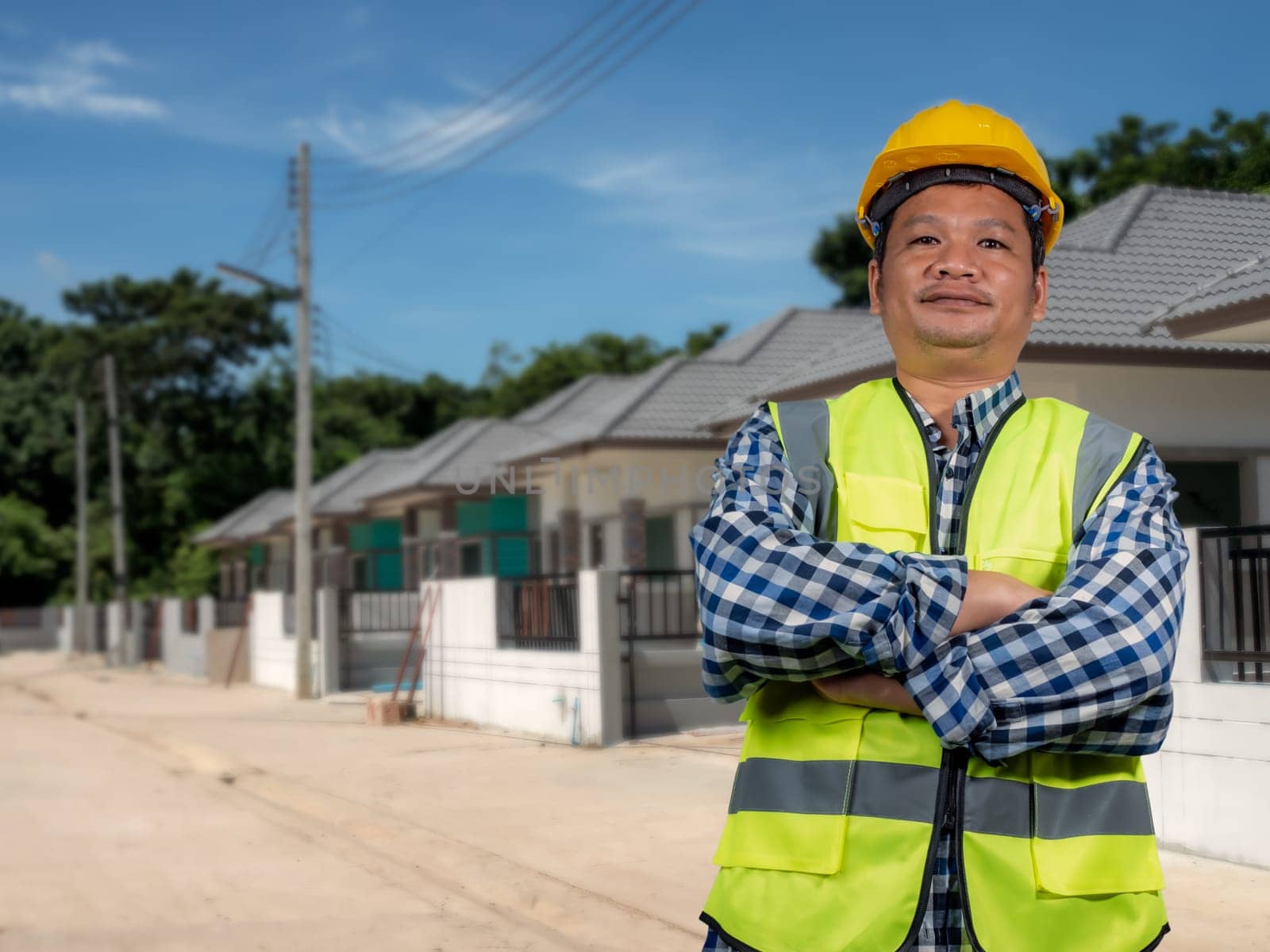 Engineer architect with protective helmet working at house building on construction site background, Housing projects, Residential construction projects.