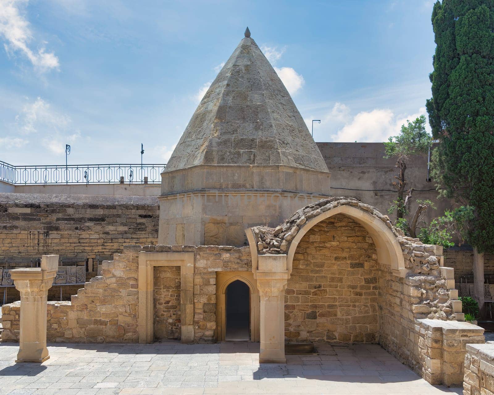 The historical Mausoleum of Seyid Yahya Bakuvi, featuring a distinctive conical roof and ancient stone architecture amidst the serene atmosphere of the Old City, Icherisheher, in Baku, Azerbaijan