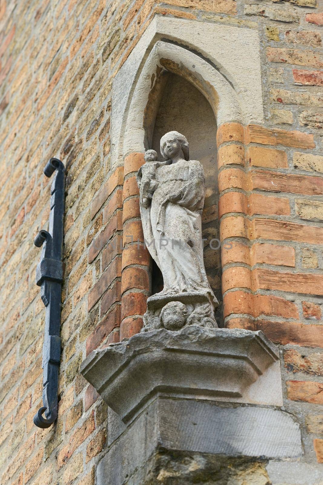 Statue of the Virgin Mary with child on a house wall in the historic old town of Bruges in Belgium