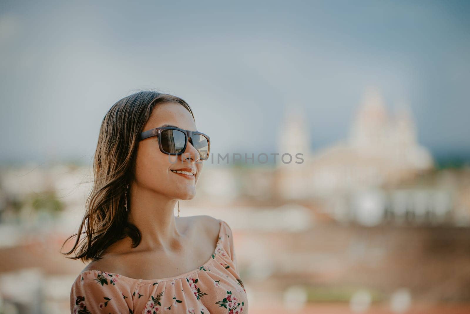 Portrait of a smiling girl in glasses with blurred background of the cathedral of Granada Nicaragua. Tourism concept