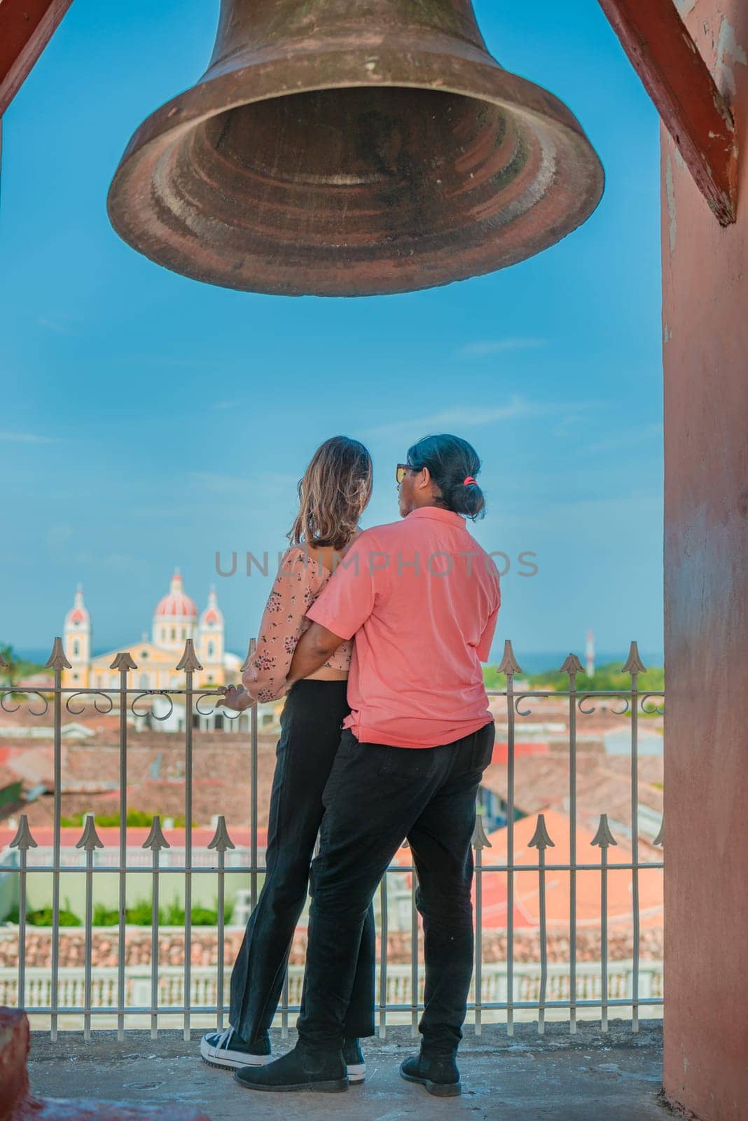 Young tourist couple looking at the Granada cathedral from the La Merced viewpoint. Tourist couple at the viewpoint of the La Merced church looking at the Granada cathedral
